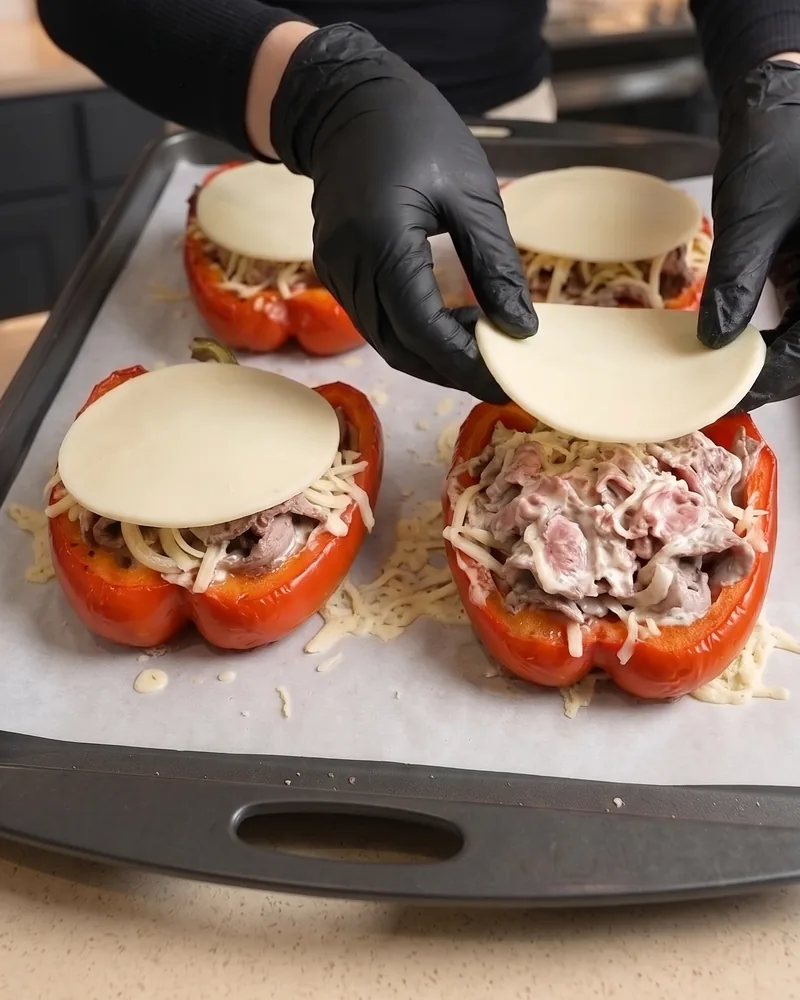 Laying provolone slices over the stuffed peppers
